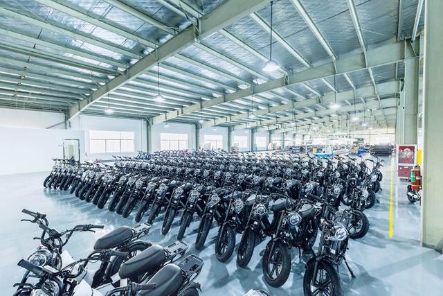 Vista interior del almacén de Linbo Transportation Tech que muestra vehículos eléctricos terminados cuidadosamente organizados, lo que ilustra el almacenamiento y la gestión de inventario eficientes.